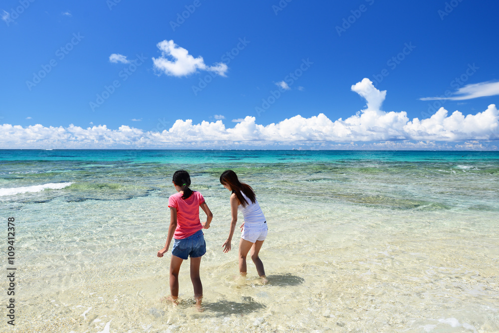 南国沖縄のビーチで遊ぶ親子
