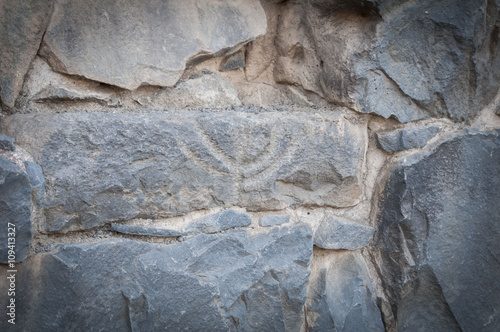 Ancient depiction of menorah in the ruins of the Talmudic-era synagogue in Katzrin. photo