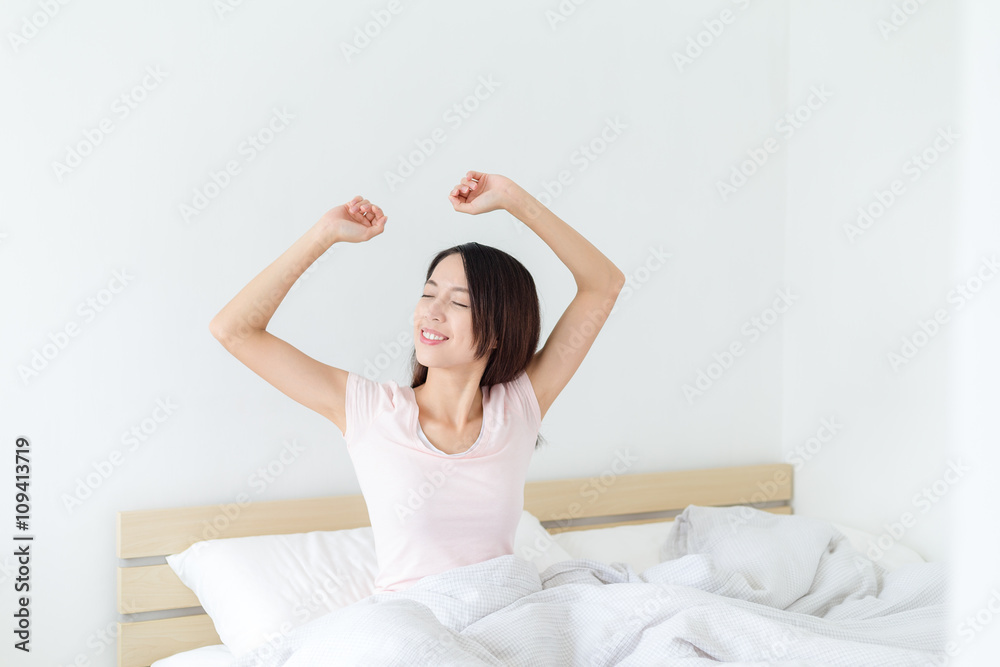 Woman waking up and yawning with a stretch Woman waking up and yawning with a stretch