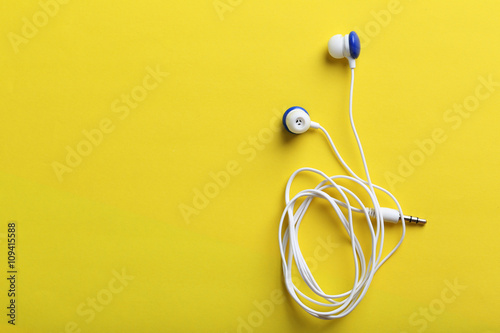 White headphones on a yellow paper background