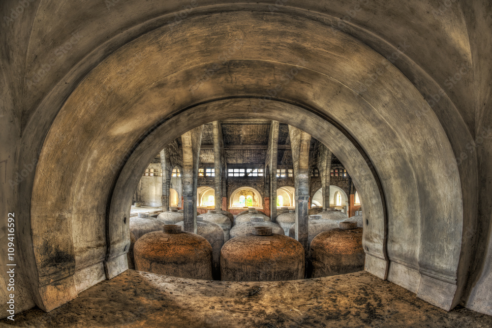View through arch of concrete fermentation tanks in an abandoned