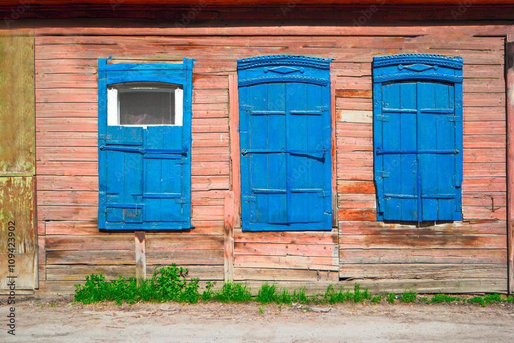 Naklejka premium Old wooden blue window of slum house in Astrakhan, Russia