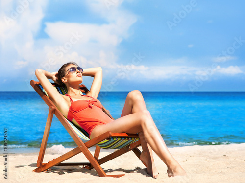 Wallpaper Mural Young and sexy woman in a deckchair on the beach