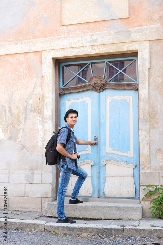 Handsome male tourist entering an old building
