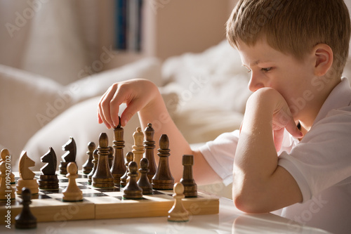 Photo Boy playing chess in the room