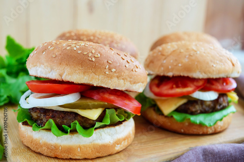 Sandwich homemade hamburger with juicy burgers, cheese,  fresh vegetables