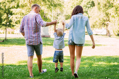 Mother and father holding their son in the park photo