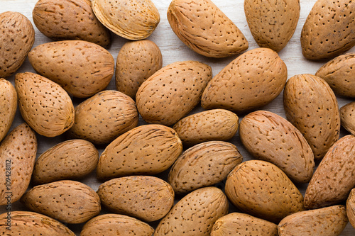 Group of almond nuts with leaves.Wooden background.