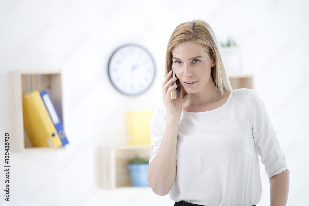 Beautiful young business woman in office talking on phone Beautiful young business woman in office talking on phone