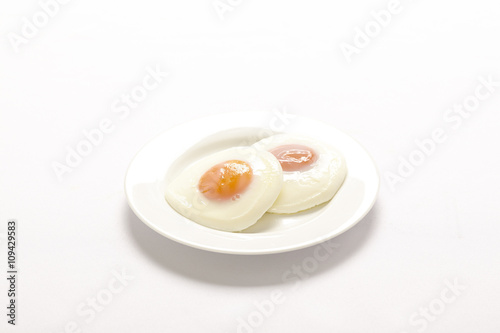 Two fried eggs with yellow yolks on white plate
