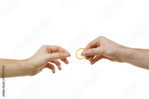 One man giving a condom to another man isolated on white