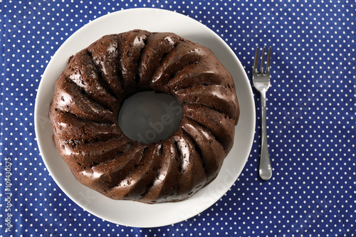 Chocolate cake on blue polka dot napkin, top view