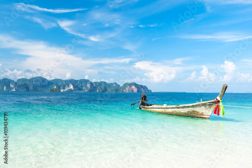 Wood boat is floating on a very clear sea water of Andaman Sea, Thailand