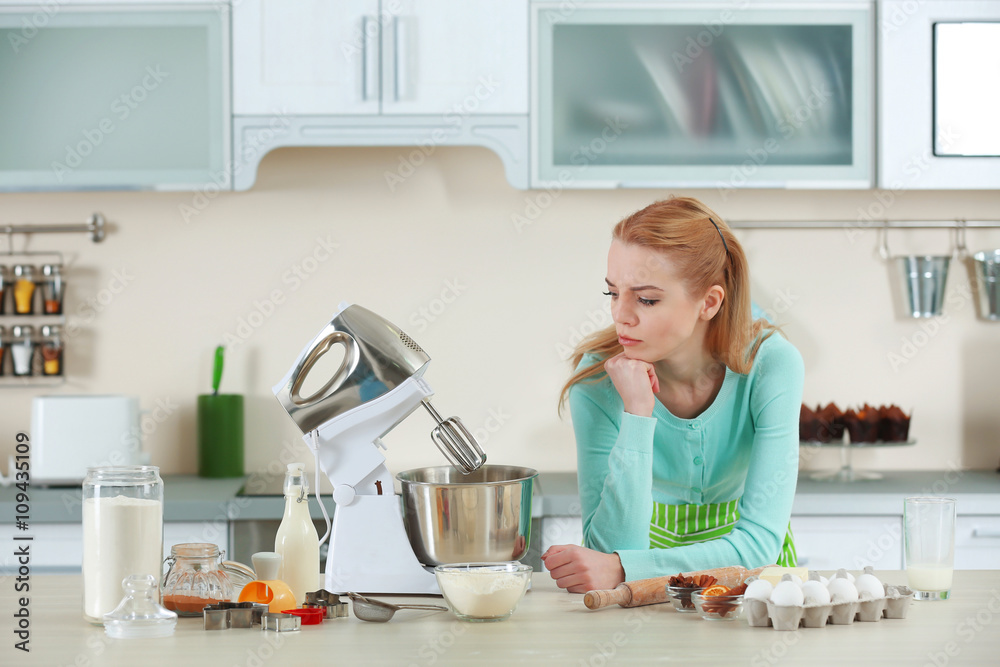 Young woman using a food processor to make a dough Young woman using a food processor to make a dough