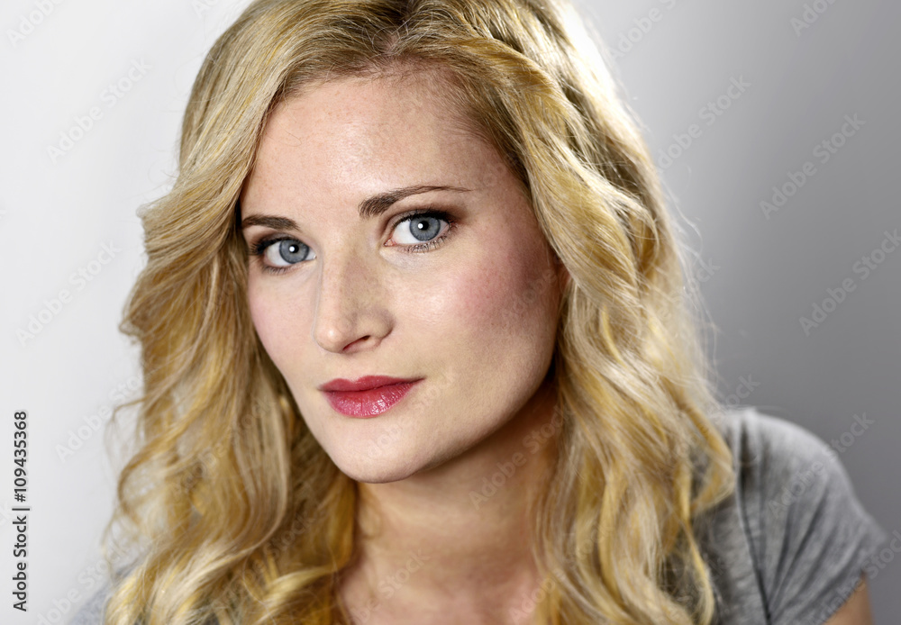 Beautiful blond woman looking to the camera. Portrait of a young woman, low key shot. Beautiful blond woman looking to the camera. Portrait of a young woman, low key shot.