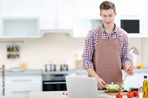 Handsome man cooking vegeta...