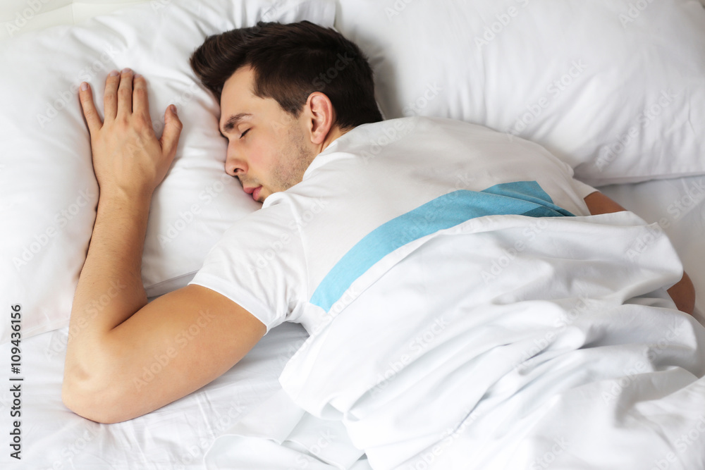 Young man sleeping on comfortable bed Young man sleeping on comfortable bed