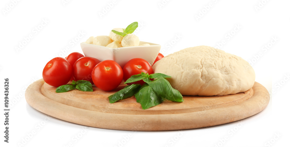 Fresh dough and other different ingredients for pizza on cutting board isolated on white