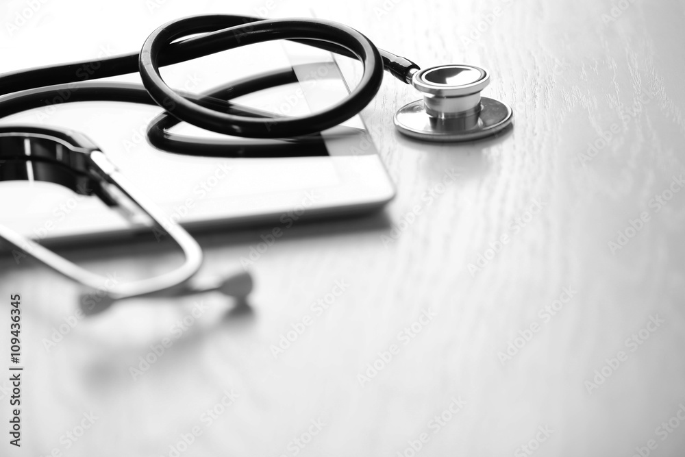 Stethoscope and tablet on wooden background Stethoscope and tablet on wooden background