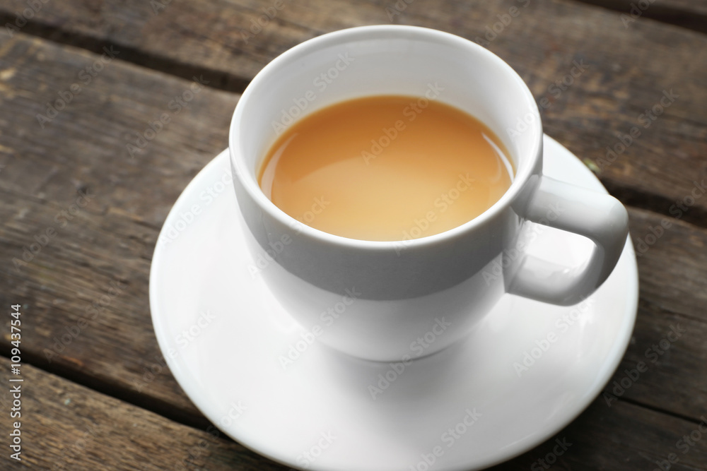 Cup of tea with milk on wooden background Cup of tea with milk on wooden background