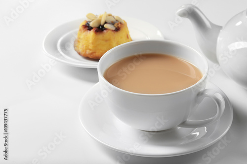 Milk tea with tea pot and a dessert on white background