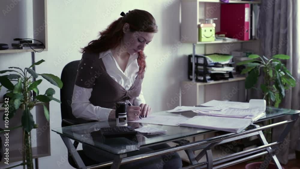 The woman signs documents and put a stamp The woman signs documents and put a stamp