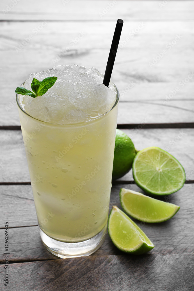 Fototapeta premium Glass of lemon soda with crushed ice and fresh mint on rustic wooden background