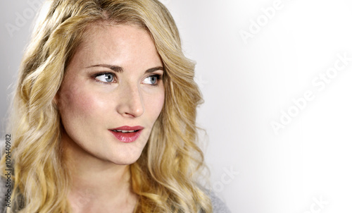 Beautiful blond woman looking to the side. Portrait of a young woman, low key shot.
