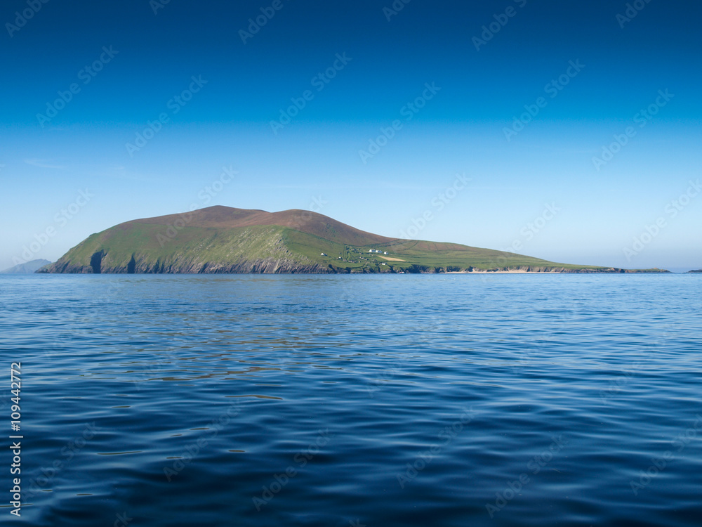 Blasket island, view from a fishing boat near the Slea Head on the Dingle Peninsula in Ireland with a clear deep blue sky