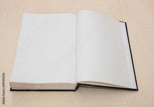 open book with black cover  on a background of beige-pink color