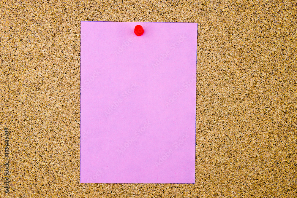 Blank violet paper note pinned on cork board Blank violet paper note pinned on cork board