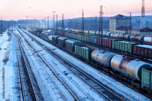 Freight train with tanks moves on railways at snowy winter