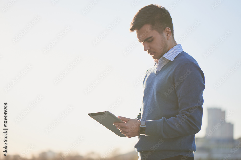 Businessman looks at tablet in his hands