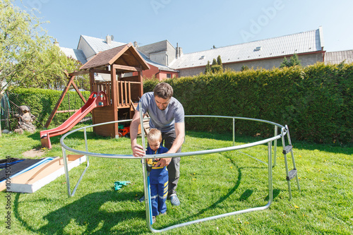 Father and son when installing large garden trampolines.