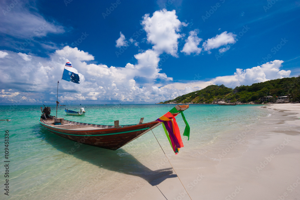 Picture of long tail boat on tropical beach. Ko li pe island. Clear water and blue sky with clouds. Horizontal Picture of long tail boat on tropical beach. Ko li pe island. Clear water and blue sky with clouds. Horizontal