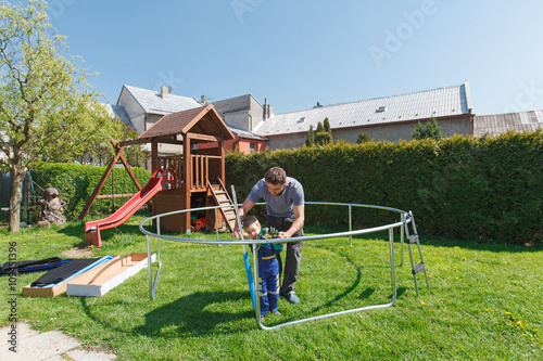 Father and son when installing large garden trampolines.