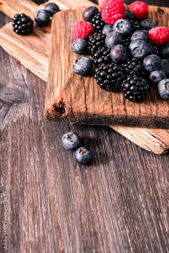 blueberries and raspberries on a wooden background