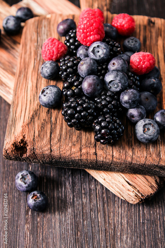 blueberries and raspberries on a wooden background