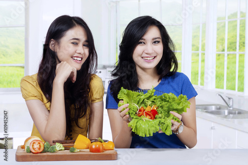 Two pretty model showing fresh salad