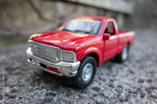 Red pick up truck toy on the road. Shallow depth of field