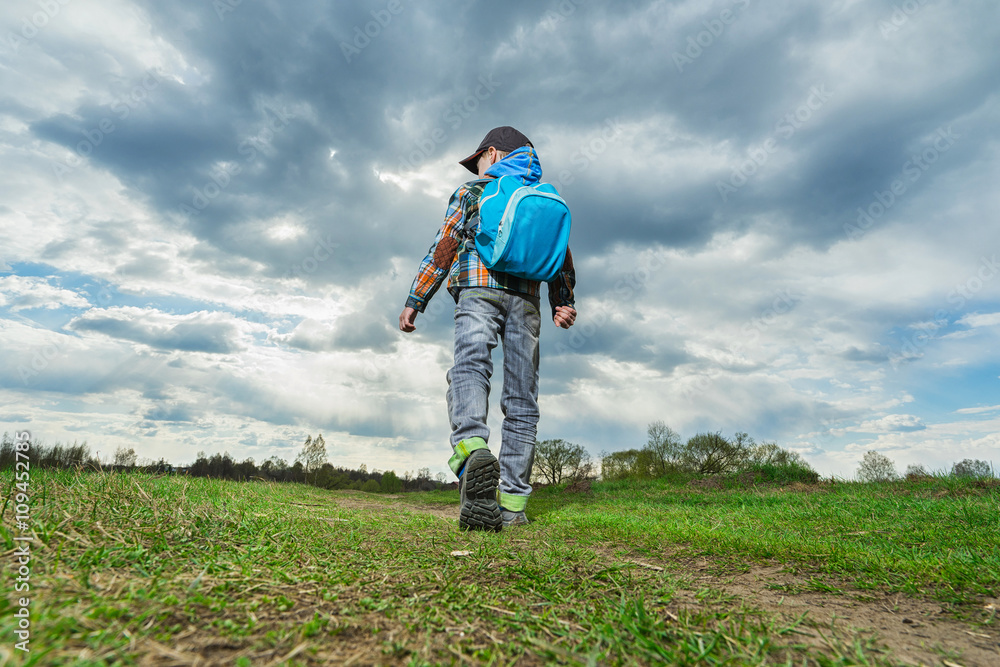 Little boy with backpack walking in nature. Travel concept. Little boy with backpack walking in nature. Travel concept.