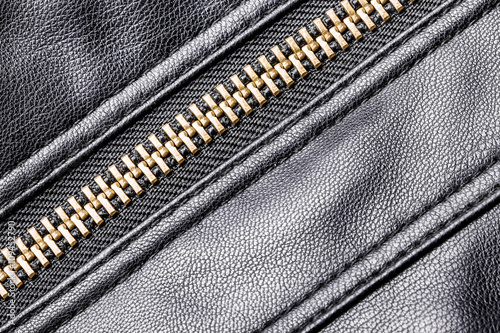 Black leather jacket metal zipper closeup.
