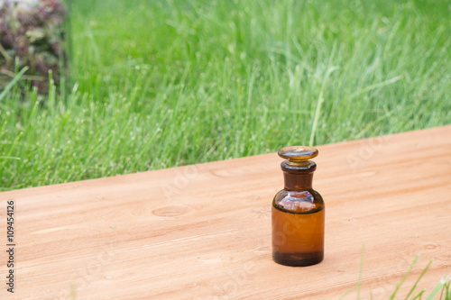 little brown bottle on booden board and grass