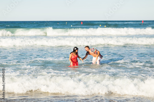 happy young couple having fun, man and woman in the sea on a beach.  © satura_
