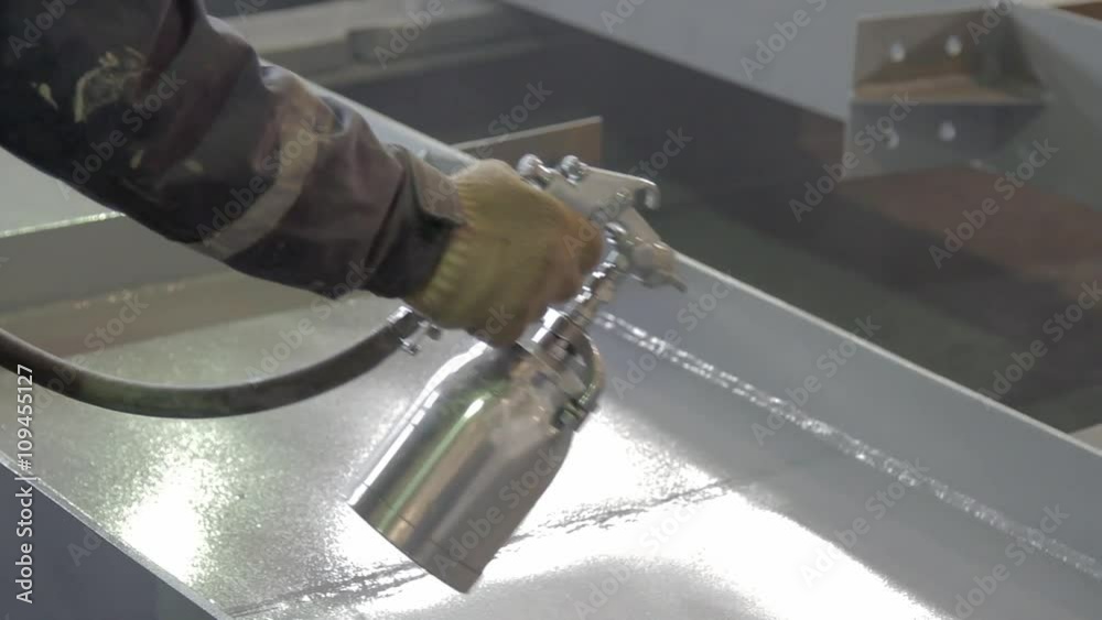 hand of worker is painting a metal beams