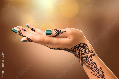 Woman's hand with mehndi tattoo. Hand of Indian bride with black henna tattoos photo