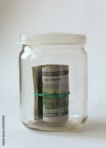 Money in glass jar on white background