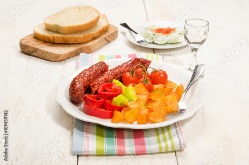 Fototapeta Naklejka Na Ścianę i Meble -  hungarian meal with fried potato, kolbasz, tomato and paprika