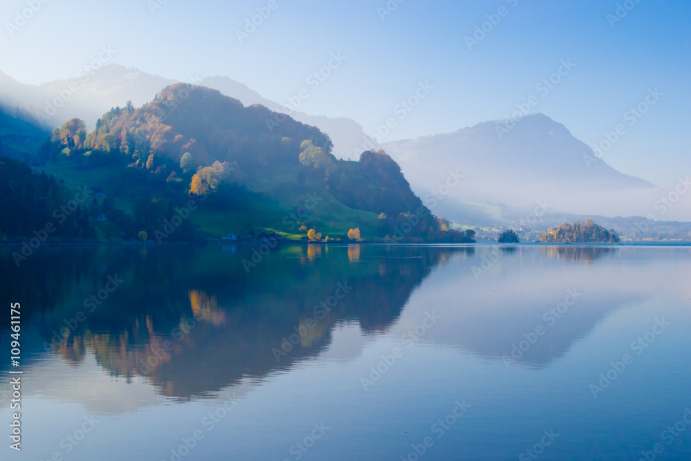 Canton Schwyz. Autumn. Reflections in calm water of the lake.