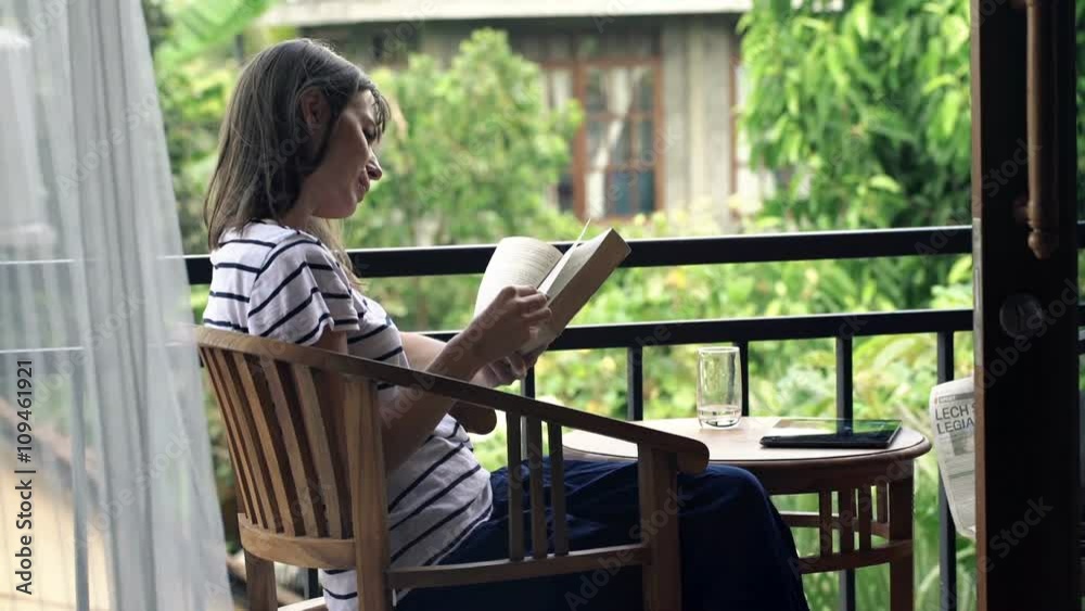Young, pretty woman reading book sitting on terrace
Young, pretty woman reading book sitting on terrace